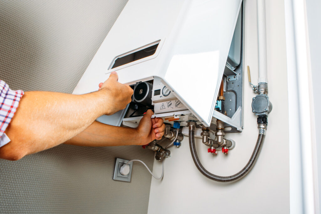 A person’s hands replacing a water heater in a Waldorf home.